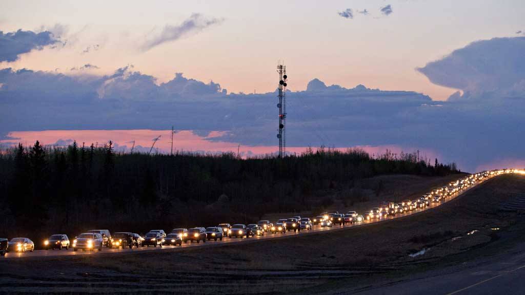 Traffic lines the highway as residents leave Fort McMurray, Alberta, Canada, on Tuesday May 3, 2016.  More than 80,000 residents were ordered to flee as a wildfire moved into the city, destroying whole neighborhoods.   (Jason Franson/The Canadian Press via AP) MANDATORY CREDIT APTOPIX Canada Wildfire