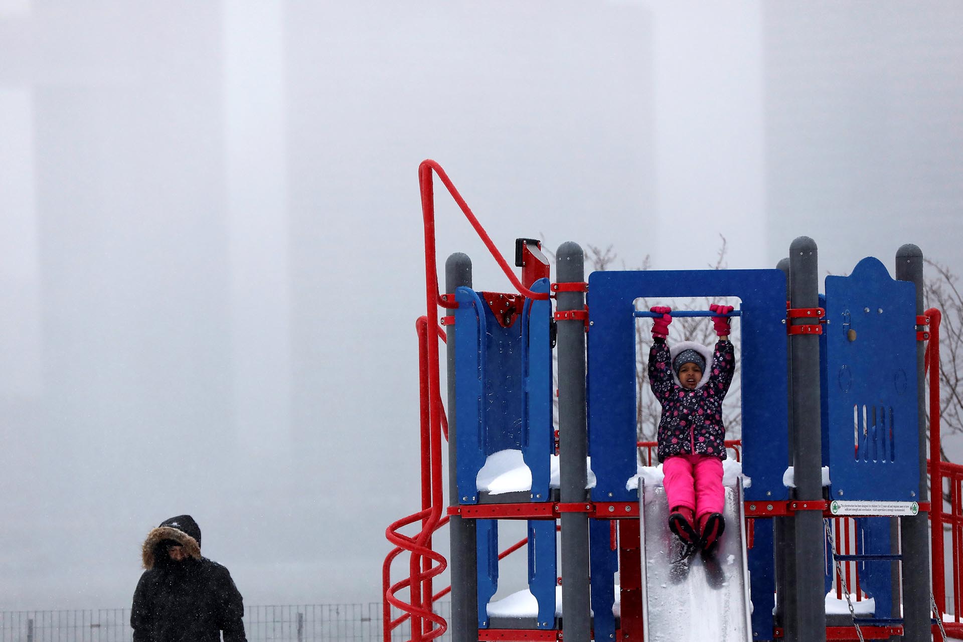 A girl goes down a slide during snowy conditions in the Queens borough of New York, U.S., March 14, 2017. REUTERS/Shannon Stapleton